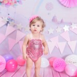 bebe menina com vestido rosa em cenario